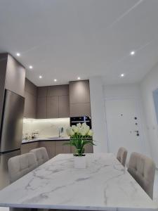 a kitchen with a table with a vase of flowers on it at Joel Family Apartment's Golem Center in Golem