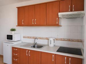 a kitchen with a sink and a microwave at Perfectly located apartment with pool in Playa de las Americas +6 photos