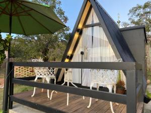 a tent with two chairs and an umbrella on a deck at Mini Cabana in Serra do Cipo