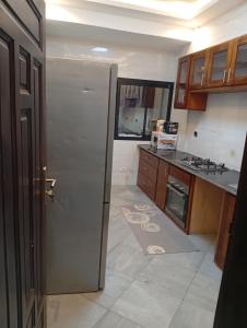 a kitchen with a refrigerator in the middle of a room at Résidence Prestige KGV Appt 304 in Douala +32 photos