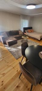 a living room with a couch and a table and chairs at Sodyba pas Babą - Apartamentai "EGLYNAS" Šventoji in Palanga