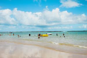 a group of people in the water at the beach at Praia do Frances - Casa Vista para o Mar - 50 metros da areia da praia in Praia do Frances