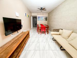 a living room with a couch and a flat screen tv at Praia do Frances - Casa Vista para o Mar - 50 metros da areia da praia in Praia do Frances