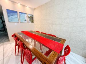 a dining room with a table and red chairs at Praia do Frances - Casa Vista para o Mar - 50 metros da areia da praia in Praia do Frances