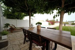 a wooden table with chairs and a bottle of wine at Casa Marieta A - Ideal per a families in Deltebre