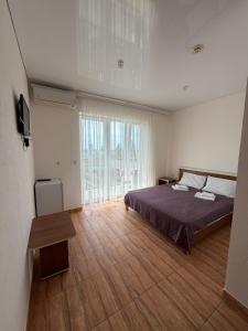 a bedroom with a bed and a large window at Sakura Hotel in Zatoka