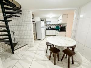a kitchen with a table and two chairs and a refrigerator at Praia do Frances - Casa Vista para o Mar - 50 metros da areia da praia in Praia do Frances +13 photos