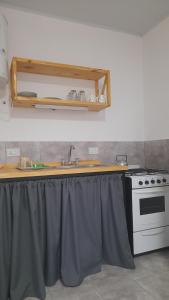 a kitchen counter with a sink and a stove at Brisa de Pueblo in Caseros