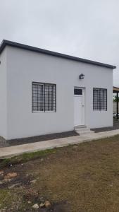 a white building with a door and windows at Brisa de Pueblo in Caseros