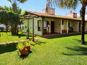 a small house with palm trees in the yard at POUSADA SERRA DA CANASTRA in Delfinópolis