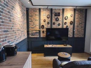 a living room with a brick wall and a table at Escale à Clisson - l'Hippo Loft in Clisson