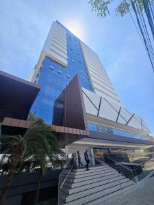 a tall building with people walking up the stairs at Life Center in Caruaru