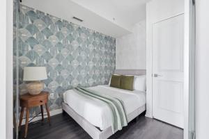a bedroom with a bed and a tiled wall at Charming 2BR downtown condo with private patio in Toronto