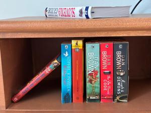 a row of books on a book shelf with a baseball bat at Apartma Prospera - free parking in Maribor