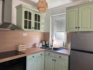 a kitchen with white cabinets and a sink at Apartma Prospera - free parking in Maribor