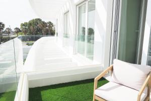 a room with a window and a chair on a balcony at Penthouse duplex with jacuzzi, 5 min to beach in Chipiona +23 photos