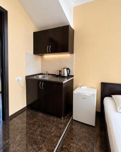 a small kitchen with a sink and a bed at Sunny Beach Hotel in Kobuleti