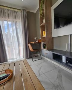 a living room with a table and a television at Montgomery Highlands Estate in Harare