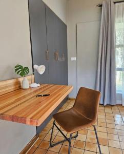 a kitchen with a wooden table and a chair at Montgomery Highlands Estate in Harare