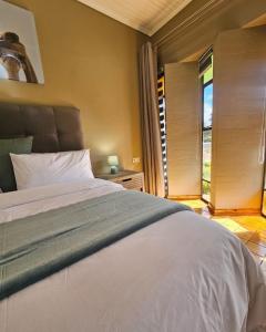 a bedroom with a large white bed and a window at Montgomery Highlands Estate in Harare