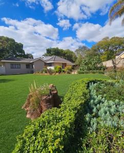 a yard with green grass and flowers at Montgomery Highlands Estate in Harare