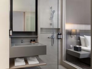 a bathroom with a sink and a shower with a mirror at Mercure Bangkok Siam in Bangkok +37 photos