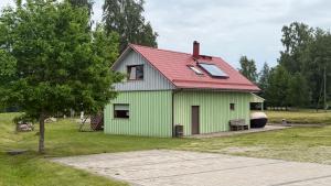 a green house with a red roof at Möllatsi Saunamaja in Möllatsi