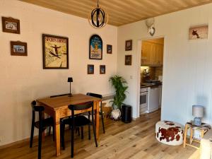 a kitchen and dining room with a table and chairs at Cabane La Folie Douce in Hotton