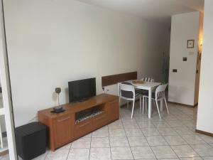 a living room with a tv and a table with chairs at LeRose in Cadine