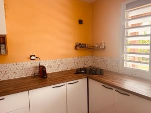 a kitchen with white cabinets and a window at Cap Alizés in Petit-Canal