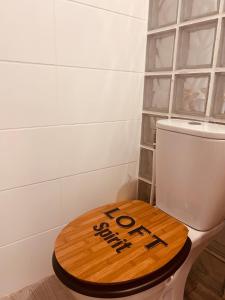 a toilet with a wooden lid on top of it at Cap Alizés in Petit-Canal