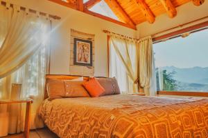 a bedroom with a bed and a large window at Paraiso de Montaña in Villa Pehuenia