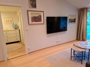 ein Wohnzimmer mit einem Flachbildfernseher an der Wand in der Unterkunft Nyrenoverad lägenhet med gratis parkering in Partille