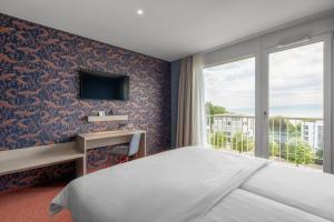 a hotel room with a bed and a window at b-smart hotel Arbon in Arbon