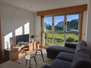a living room with a couch and a large window at Brisas de Malpica in Malpica