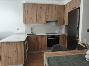 a kitchen with wooden cabinets and a black refrigerator at Brisas de Malpica in Malpica