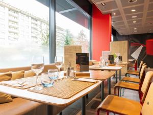 a restaurant with tables and chairs with wine glasses at ibis Genève Centre Nations in Geneva
