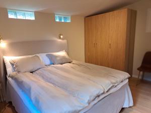 ein Schlafzimmer mit einem großen Bett mit weißen Laken und Kissen in der Unterkunft Nyrenoverad lägenhet med gratis parkering in Partille