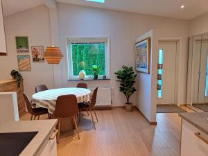 eine Küche und ein Esszimmer mit Tisch und Stühlen in der Unterkunft Nyrenoverad lägenhet med gratis parkering in Partille