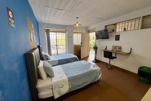 a bedroom with two beds and a blue wall at Our Home San Antonio in Cali