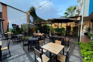 an outdoor patio with tables and chairs and an umbrella at Our Home San Antonio in Cali