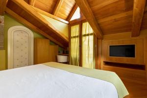 a bedroom with a white bed and a tv at Villa Di Natale in Pagani