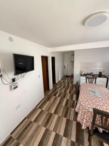 a room with a table and a television on a wall at Colibrí in Merlo +8 photos