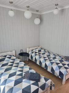 two beds in a room with checkered at Apšuciema Birzīši in Apšuciems