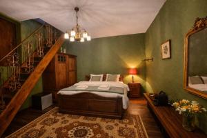 a bedroom with a bed and a staircase with a mirror at B&B Pronkenburg in Lissewege