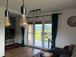 a living room with a couch and a sliding glass door at Wonderland Apartamenty in Bukowiec