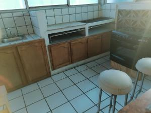 a kitchen with a stove and two stools in it at Hotel 7 Rooms in Guadalajara +11 photos