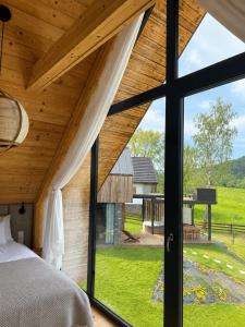 a bedroom with a large window looking out at a yard at Krzywe Pearl Chalets in Krywe +234 photos