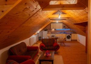 a living room with two chairs and a table at Golden Serafín - Romantic apartment below Karlštejn in Karlštejn
