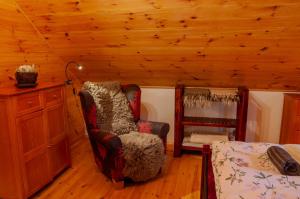 a room with a chair and a bed in a cabin at Golden Serafín - Romantic apartment below Karlštejn in Karlštejn +14 photos